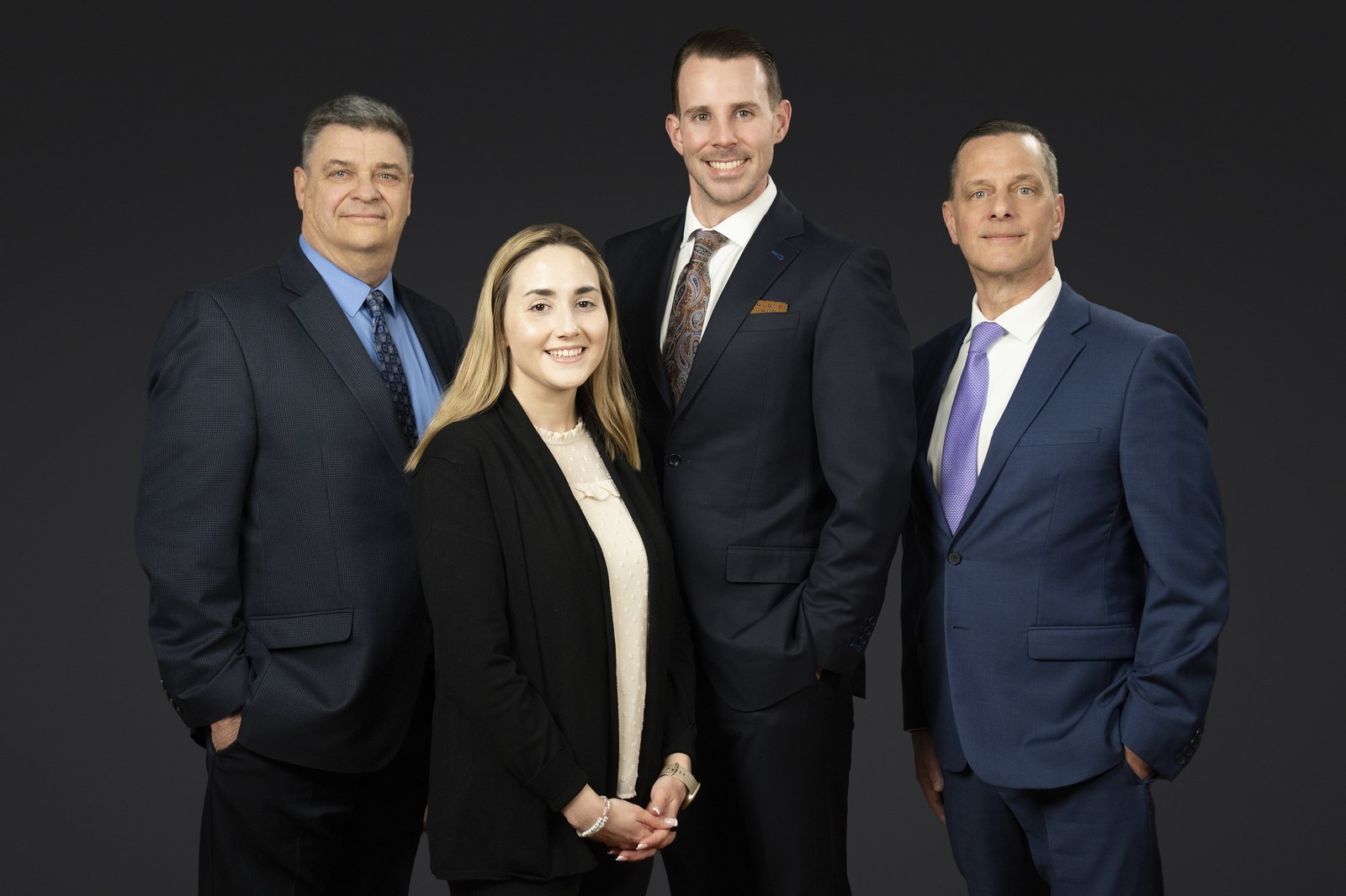 Four colleagues photographed on the same backdrop and lighting for a consistent team look