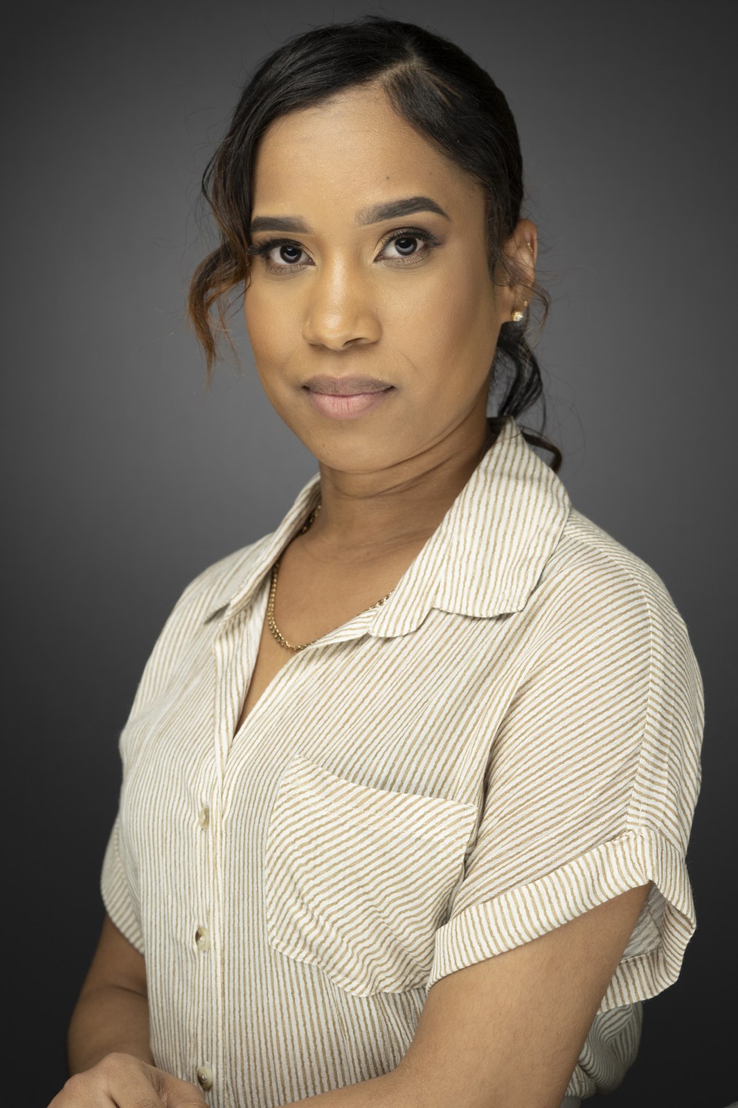 A studio headshot shot on the same matched backdrop and lighting as the rest of the team
